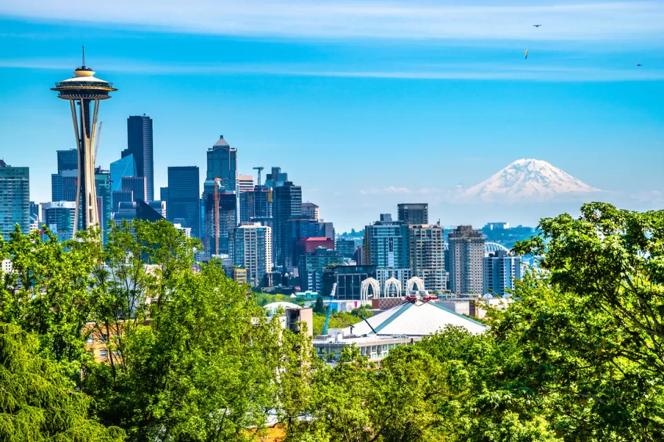 View of Seattle skyline on clear sunny day with Space Needle on left and Mount Rainier in the background.